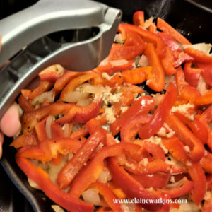 Adding garlic to a quick and easy recipe of Sautéed Peppers and Onions as a flavorful topping